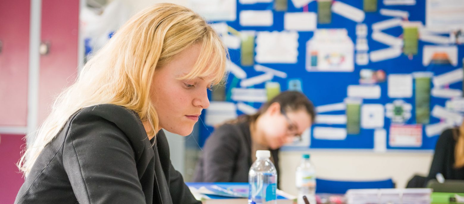 girls in a classroom writing