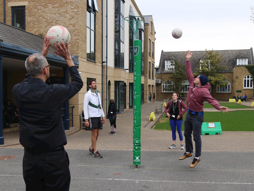 staff members throwing balls into a hoop