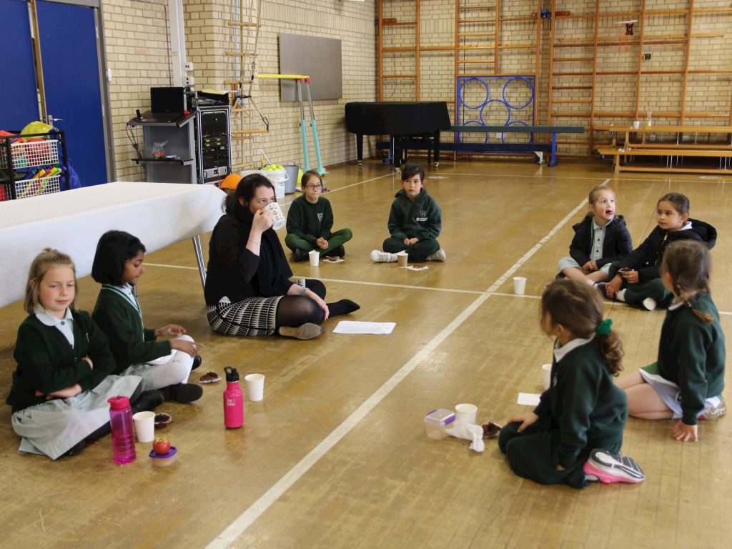 teacher and pupils sat on the floor