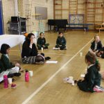 teacher and pupils sat on the floor