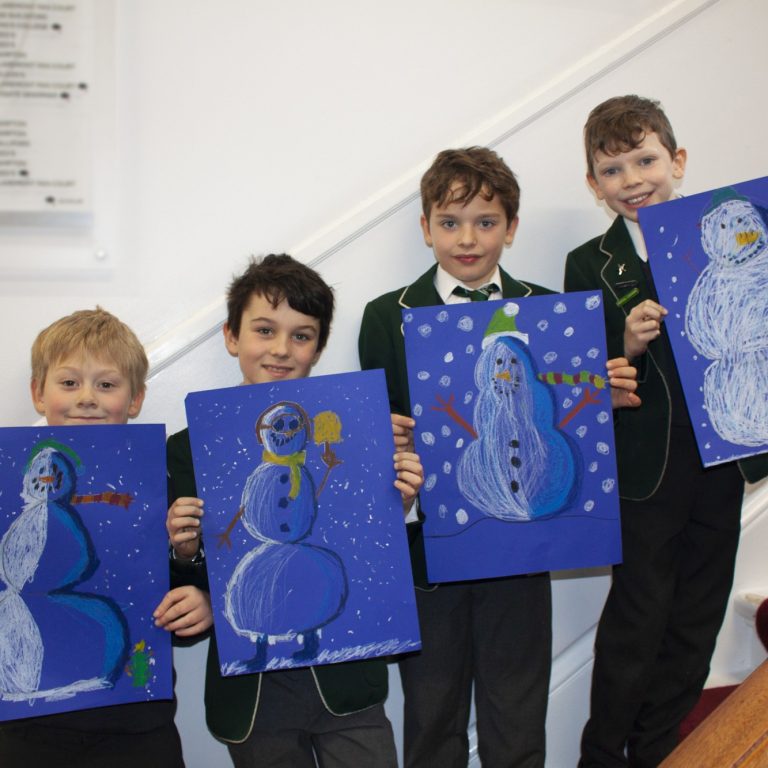 students holding their art work