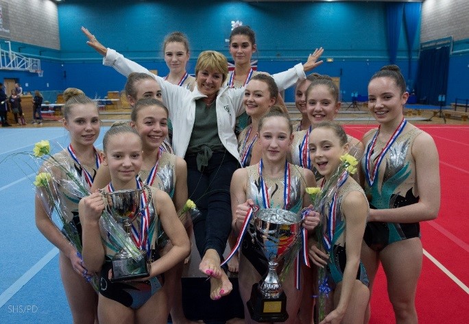students and teachers with their trophies, medals and flowers