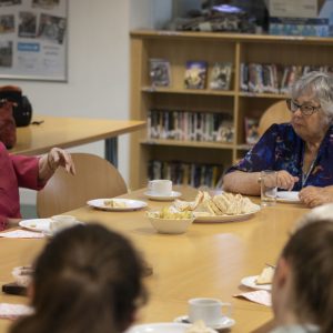 2 elderly women eating sandwiches