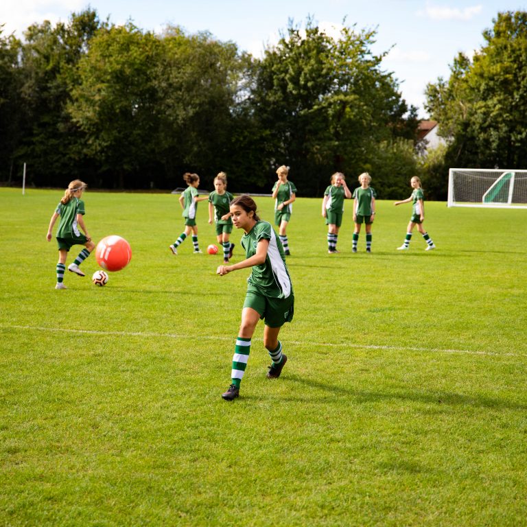 student kicking football