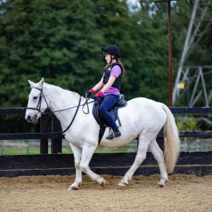 student on a white-coloured horse