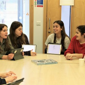 students talking over iPads