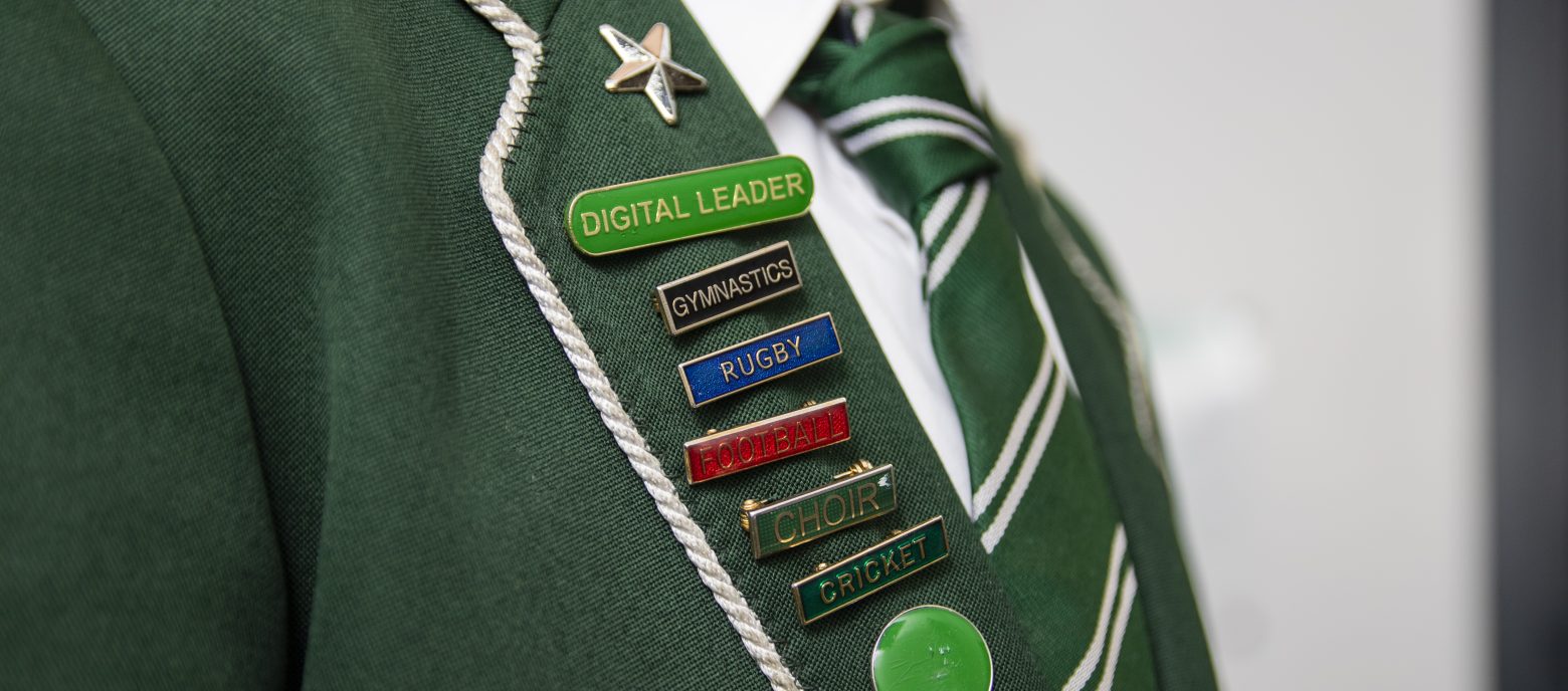 a green blazer with lots of pin badges