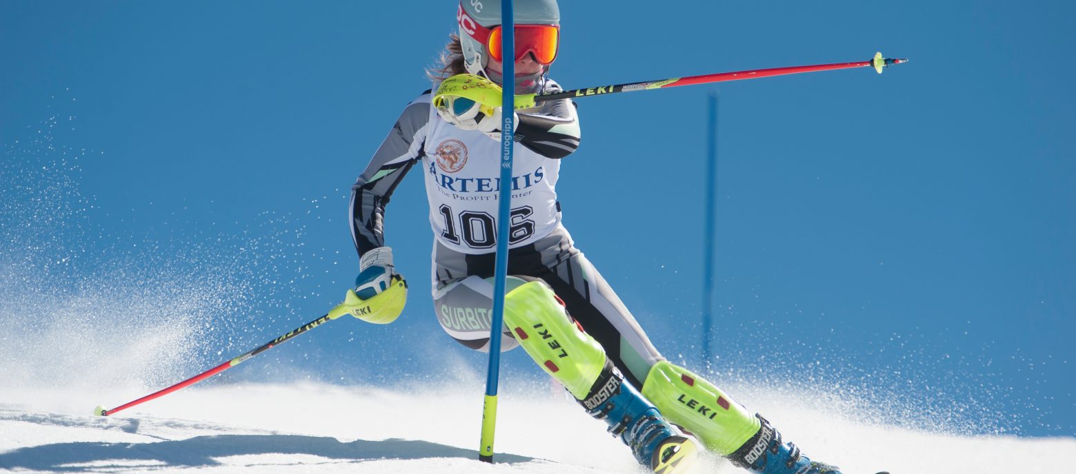 student skiing across a slalom pole