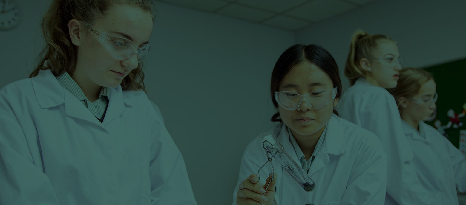 Students wearing lab coats doing an experiment