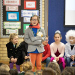 Year 3 pupil standing in assembly hall