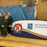 girls stood next to bluebay asset management sign