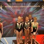 4 children in gymnastics clothes wearing medals