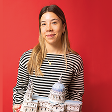 student holding a model building