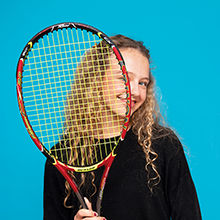 student holding a tennis racquet