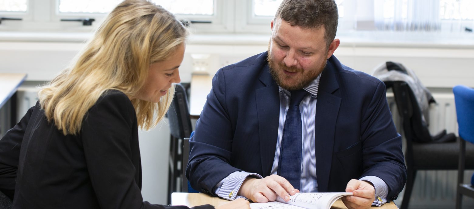 teacher going through a book with a student