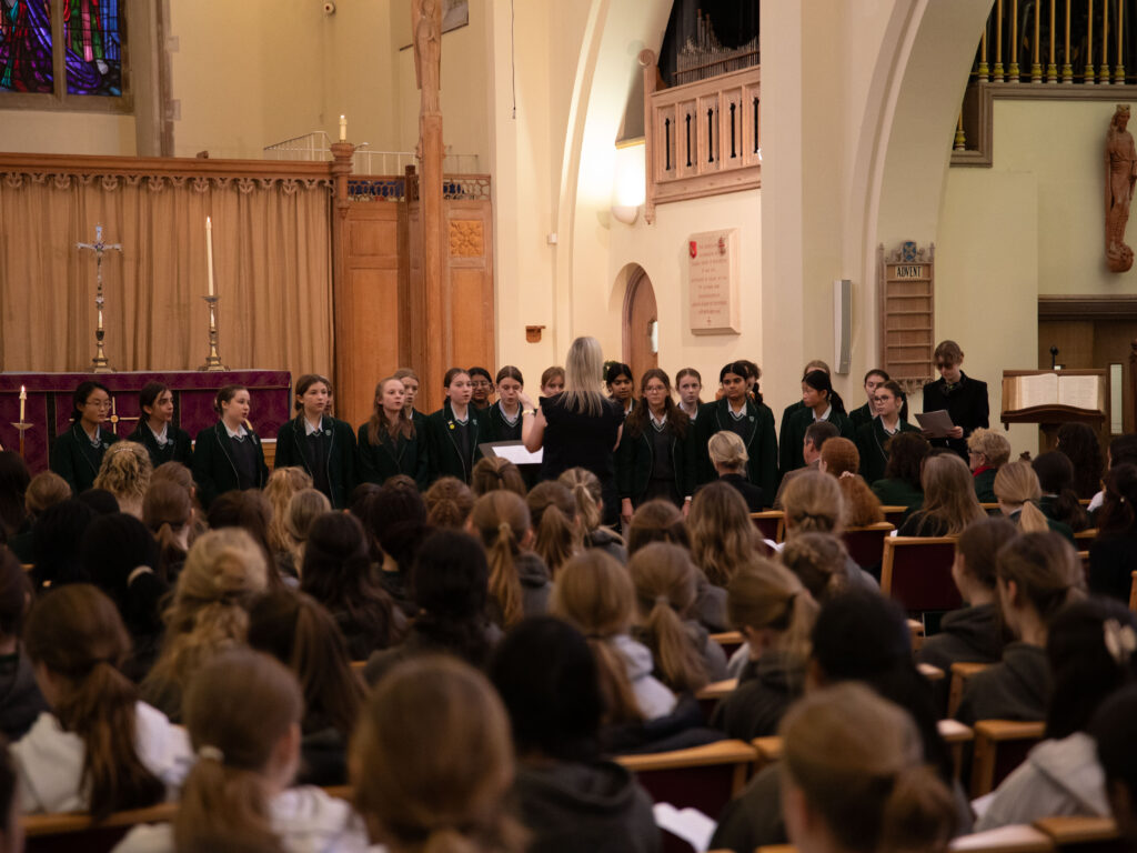 Pupils in uniform standing in church hall