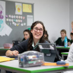 Young female student in classroom smiling at camera