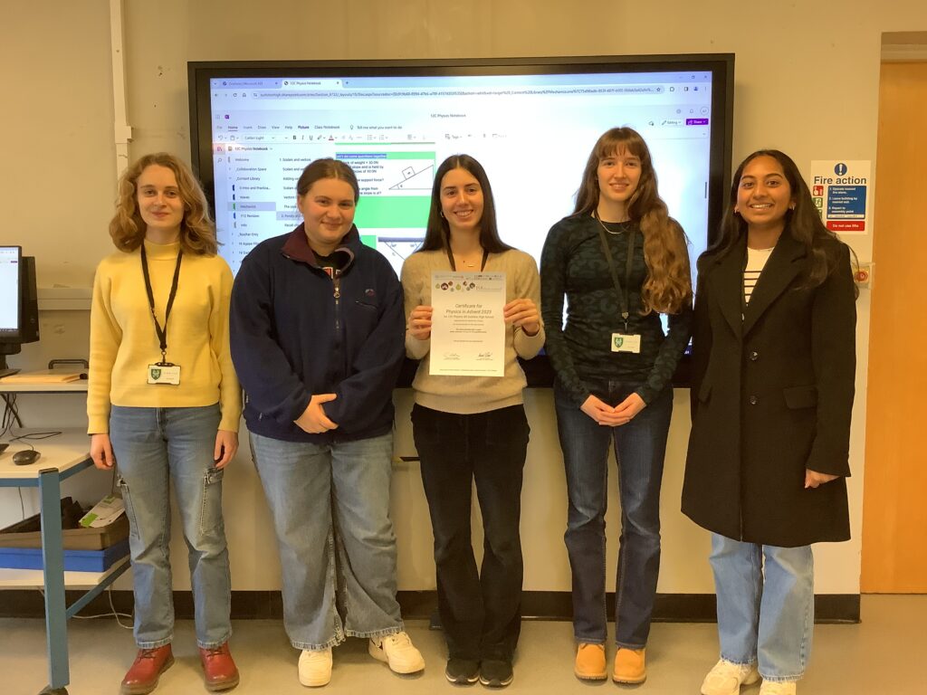 5 students standing in a row, and one student holding certificate