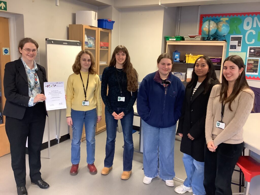 Five female students with lanyards smiling at camera