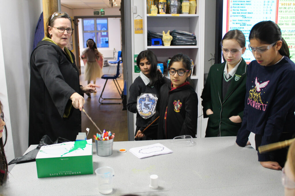 Teacher and pupils dressed in Harry Potter attire in classroom