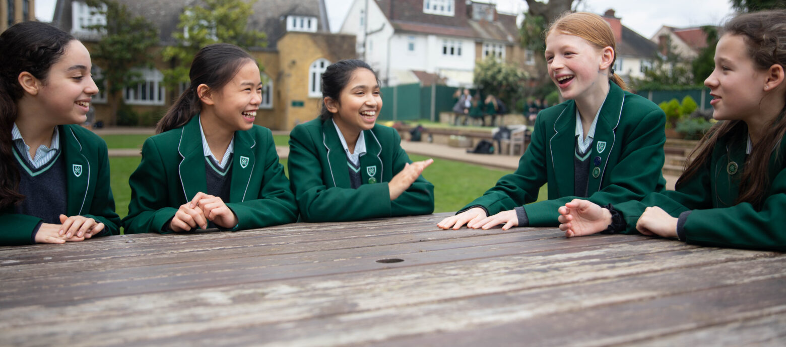 girls sat at an outdoor table