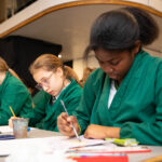 Girls in art aprons drawing